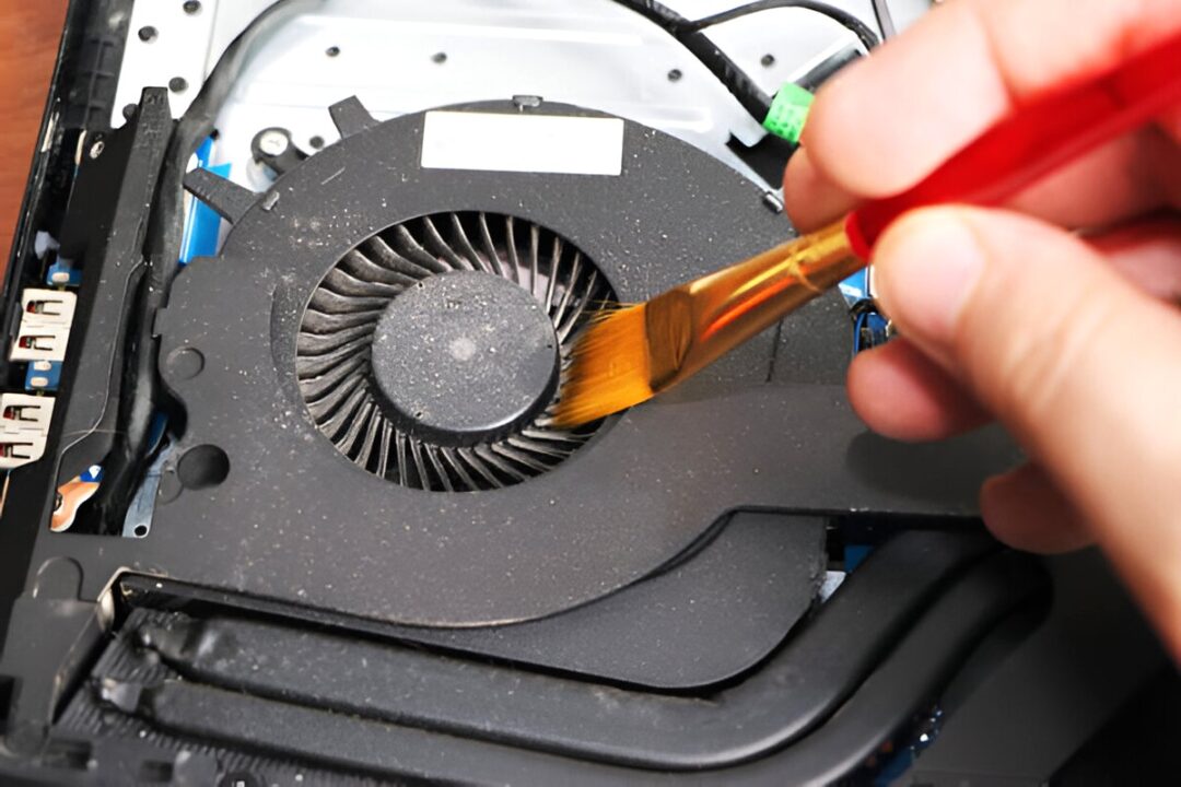 Cleaning a Laptop Fan Using a Soft Brush 